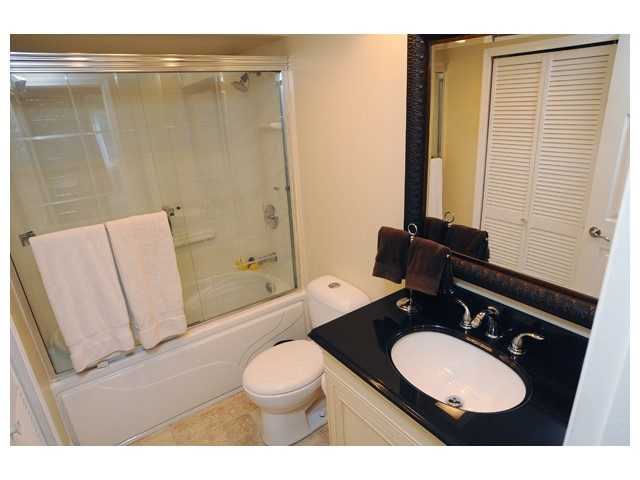 Bathroom with black countertop, white sink, and glass shower. - 1889  Alderlynn Drive, North Vancouver
