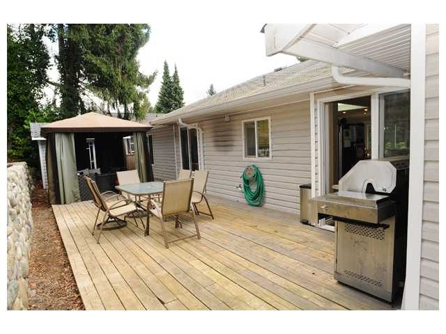 Furnished deck with outdoor furniture and grill, surrounded by trees. - 1889  Alderlynn Drive, North Vancouver