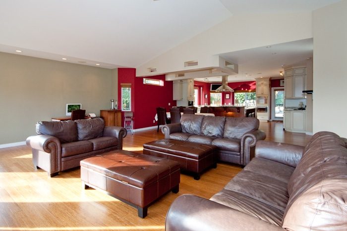 Open-concept living room with hardwood floors and a modern kitchen in the background. - 967 Roslyn Blvd., North Vancouver