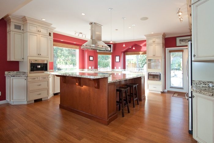 Bright kitchen with red walls, granite countertops, and hardwood floors. - 967 Roslyn Blvd., North Vancouver