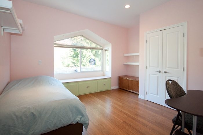 Bright bedroom with hardwood floors, green cabinets, and a city view. - 967 Roslyn Blvd., North Vancouver