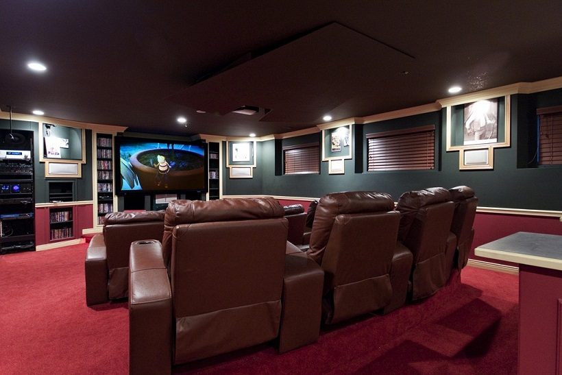 Home theater with plush recliners and a large screen displaying a movie. - 967 Roslyn Blvd., North Vancouver