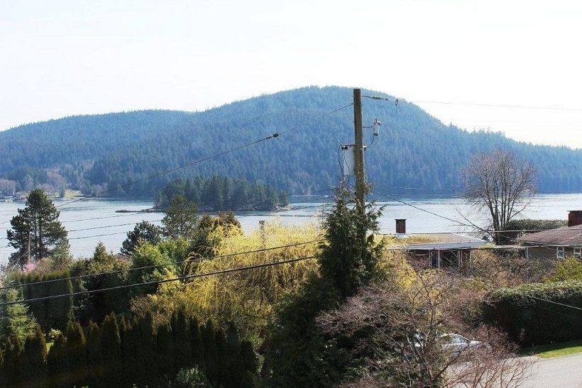Bright living room with a view of the lake and mountains. - 967 Roslyn Blvd., North Vancouver