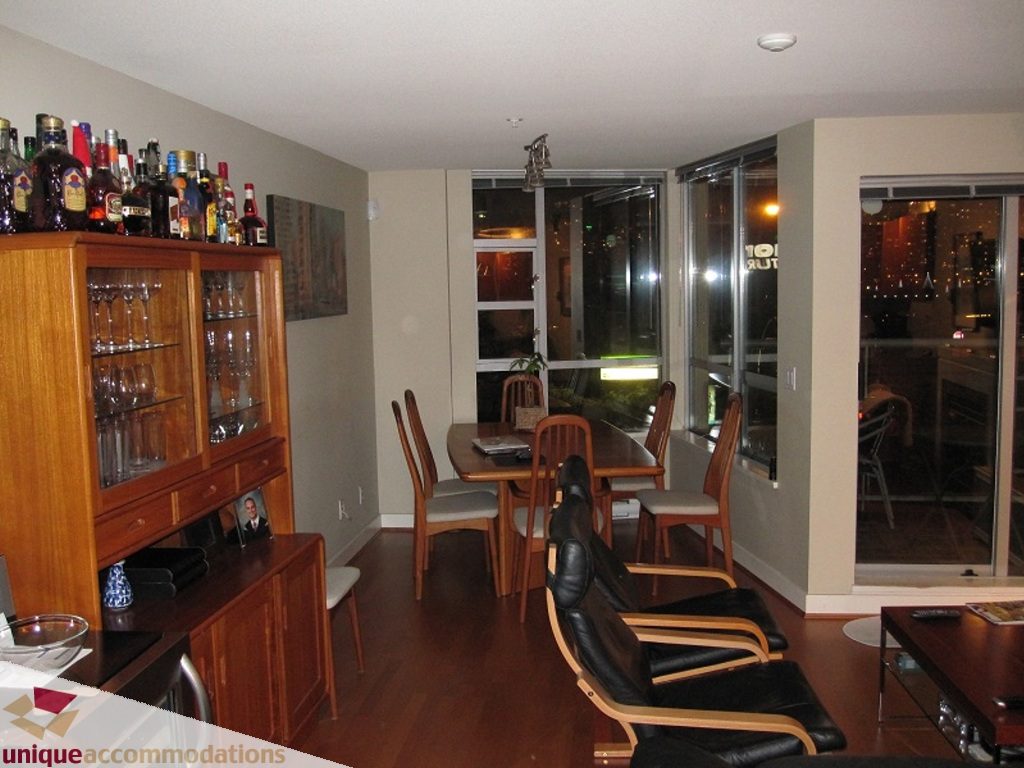 Furnished dining area with hardwood floors, city view, and wooden furniture. - 6-1250 West 6th Ave, Vancouver West Side