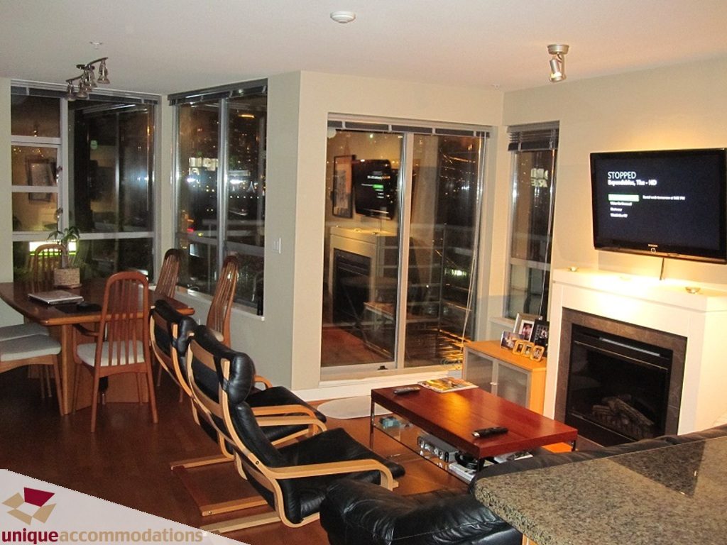 Furnished living room with hardwood floors, city view, and granite countertops. - 6-1250 West 6th Ave, Vancouver West Side