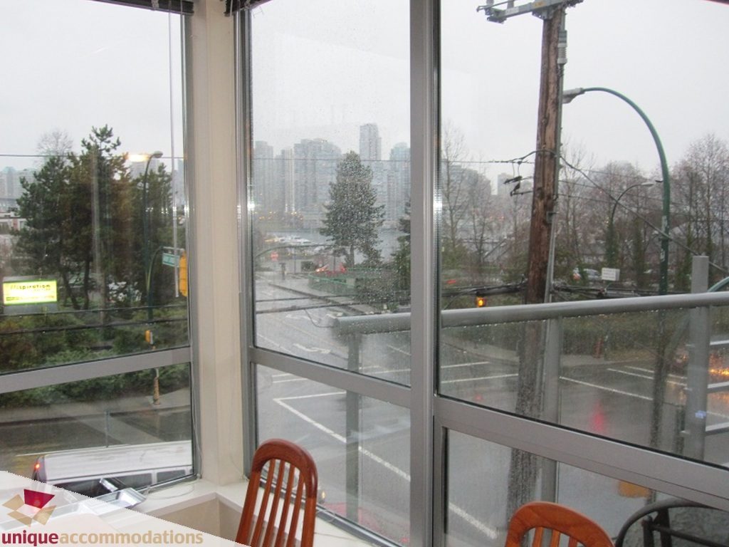 Furnished living room with large windows offering a city view. - 6-1250 West 6th Ave, Vancouver West Side