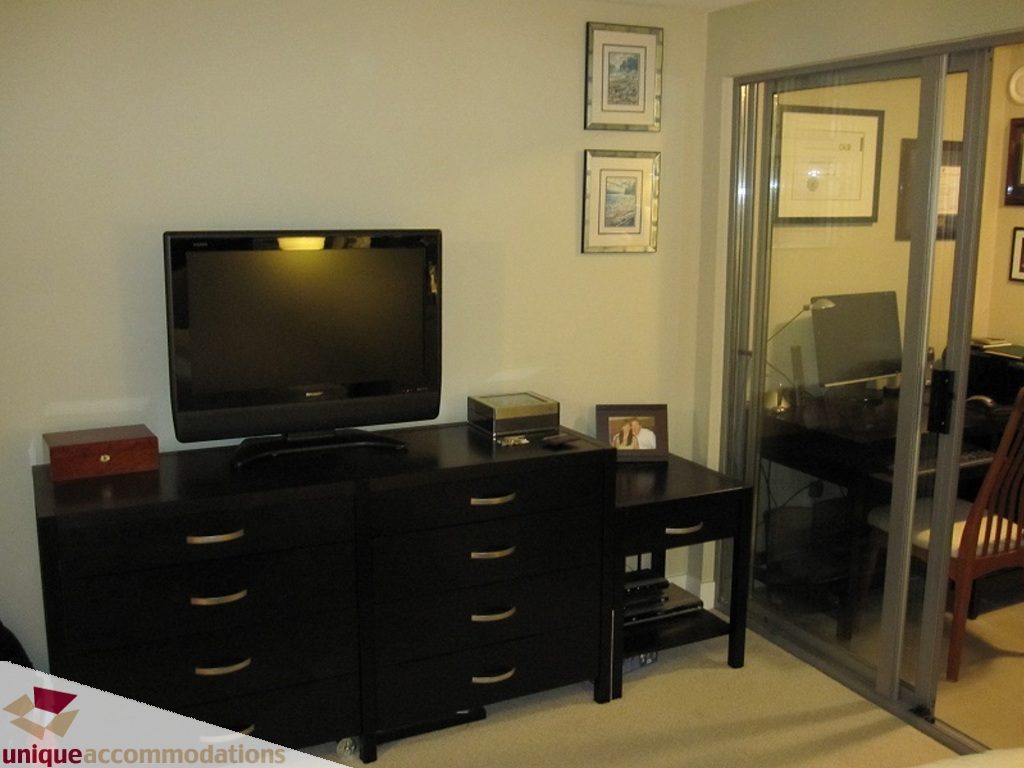 Living room with dark wood furniture and a flat-screen TV. - 6-1250 West 6th Ave, Vancouver West Side