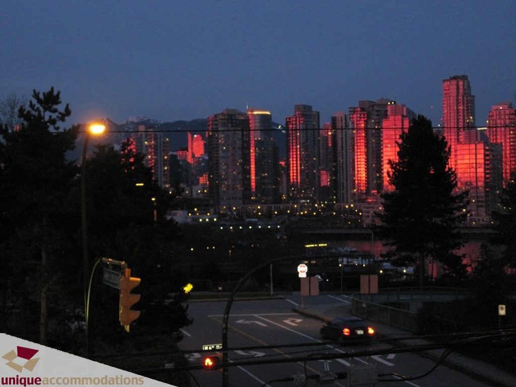 Furnished 2-bedroom condo with a stunning city view at dusk. - 6-1250 West 6th Ave, Vancouver West Side