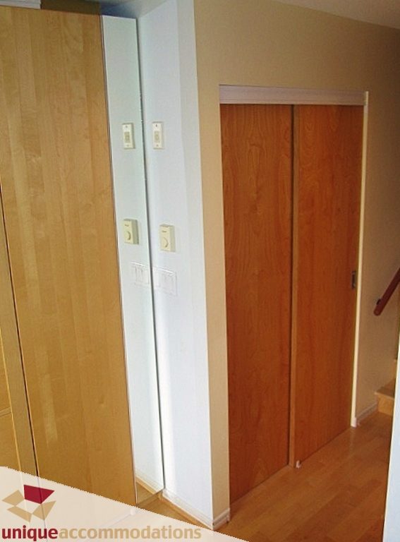 Furnished hallway with wooden doors and light switch panel. - 306-3727 West 10th Ave, Vancouver West Side