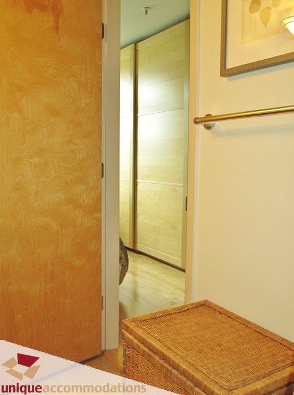 Furnished entryway with wooden closet doors and wicker basket. - 306-3727 West 10th Ave, Vancouver West Side