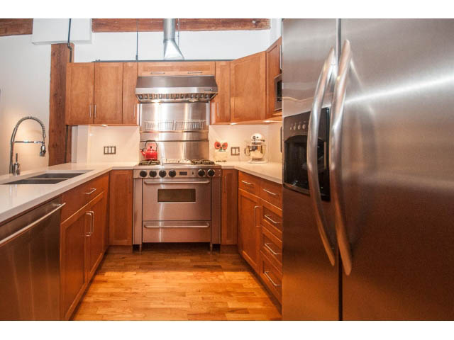 Bright kitchen with stainless steel appliances, hardwood floors, and a city view. - 410 - 550 Beatty Street, Vancouver Downtown