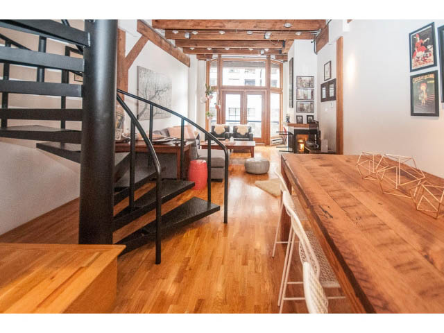 Bright living room with hardwood floors and modern decor, featuring a staircase and city view. - 410 - 550 Beatty Street, Vancouver Downtown
