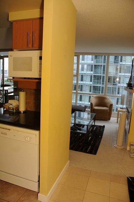 Bright kitchen with black countertops and city view. - 1501 -1077 Marinaside Crescent, Vancouver Downtown