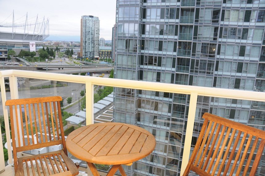 Furnished balcony with wooden furniture and city view. - 1501 -1077 Marinaside Crescent, Vancouver Downtown