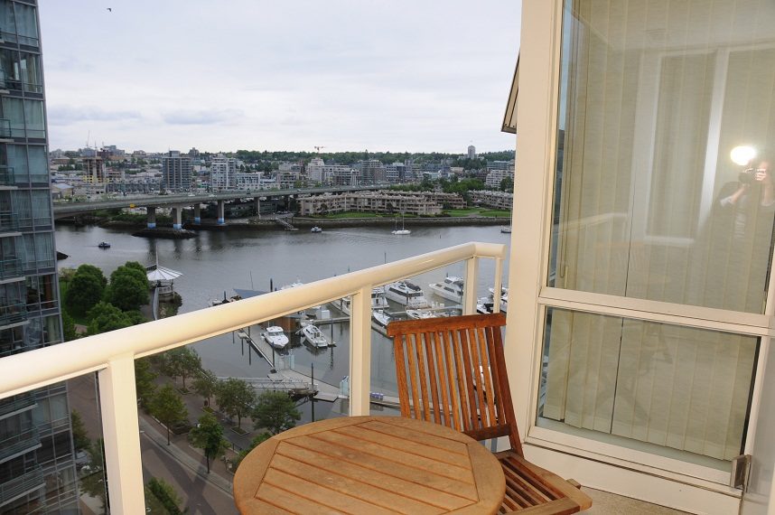 Bright balcony with city view, wooden furniture, and marina in the distance. - 1501 -1077 Marinaside Crescent, Vancouver Downtown