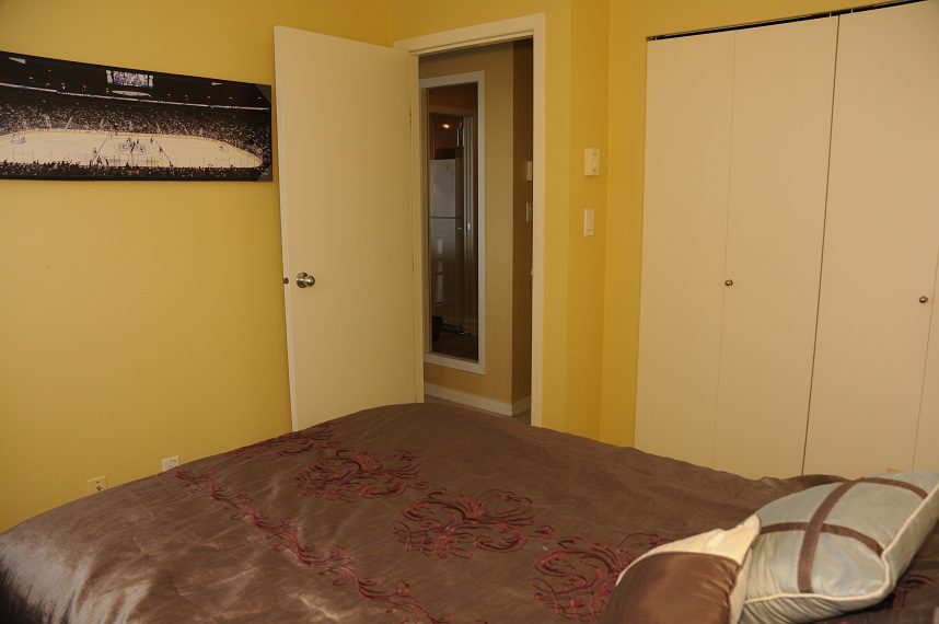 Furnished 1-bedroom + den with a hockey game poster and a closet. - 1501 -1077 Marinaside Crescent, Vancouver Downtown