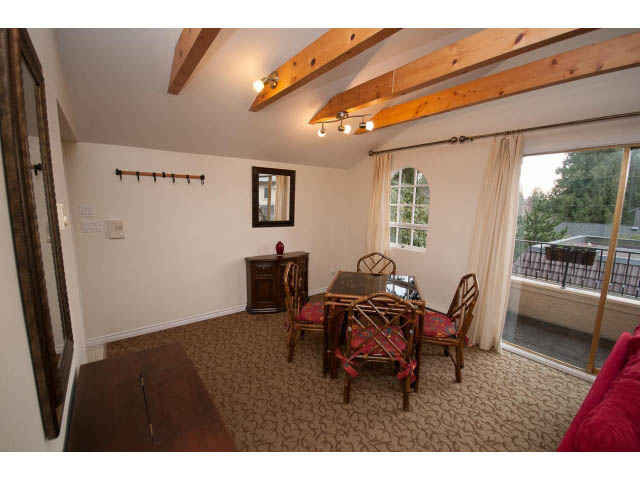 Furnished living room with exposed beams, large windows, and a cozy seating area. - Cottage - Sinclair Street, West Vancouver