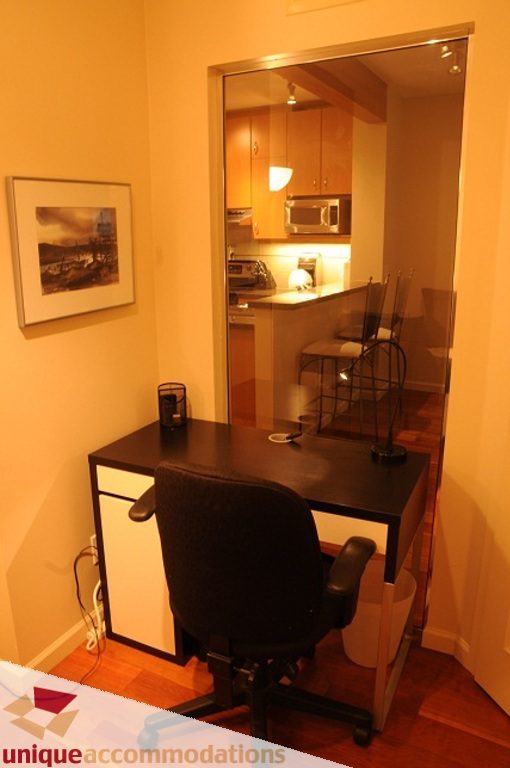 Furnished den with desk, chair, and hardwood floors. - 212- 580 Raven Woods Drive, North Vancouver