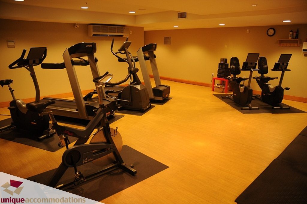 Fitness room with cardio machines and exercise equipment. - 212- 580 Raven Woods Drive, North Vancouver