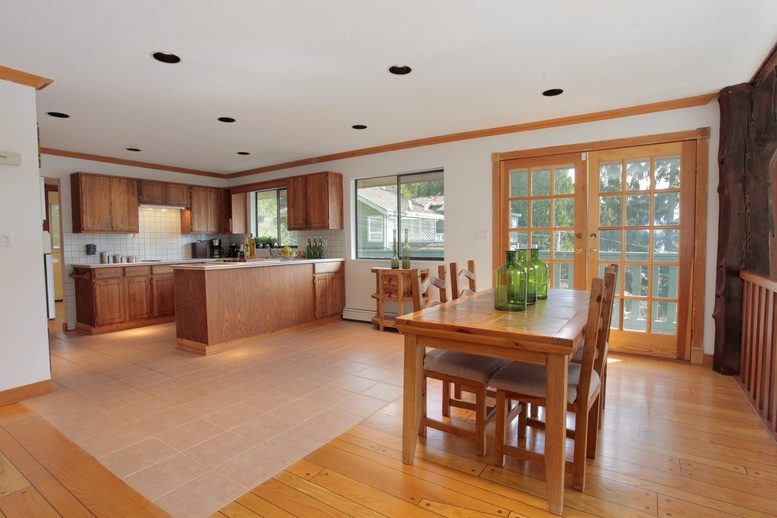 Open-concept dining and kitchen area with hardwood floors and large windows. - 2758 Panorama Drive, North Vancouver