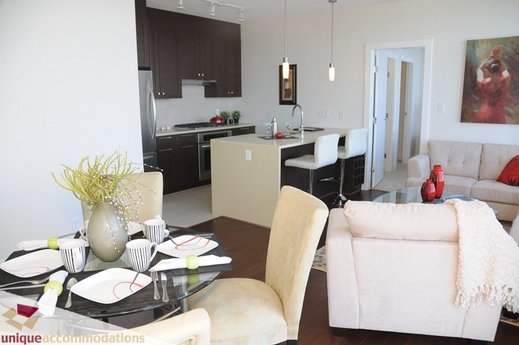 Furnished dining area with modern decor, hardwood floors, and a cozy living space. - 3401 - 888 Homer Street, Vancouver Downtown