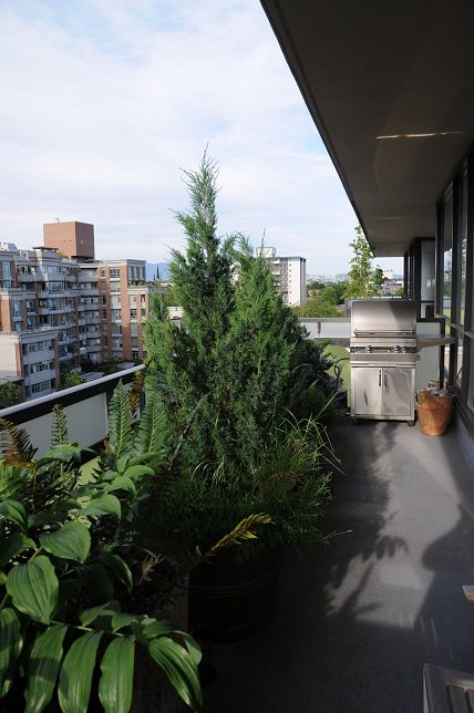 Balcony with city view, BBQ, and lush greenery. - 903-718 Main Street, Vancouver Downtown