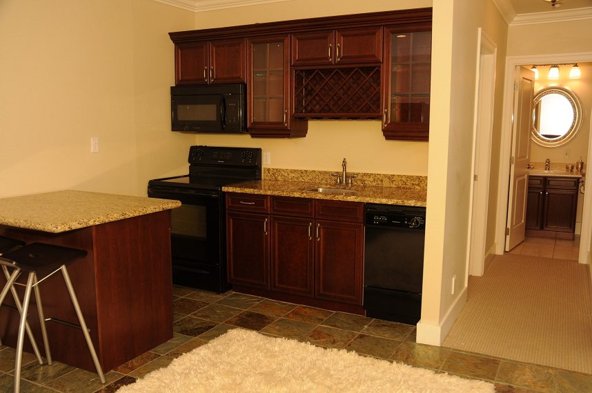 Bright kitchen with granite countertops and dark wood cabinets. - 4069 West 37th Ave, Vancouver West Side