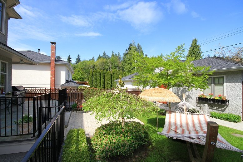 Bright patio with outdoor furniture, hammock, and lush greenery. - 4069 West 37th Ave, Vancouver West Side