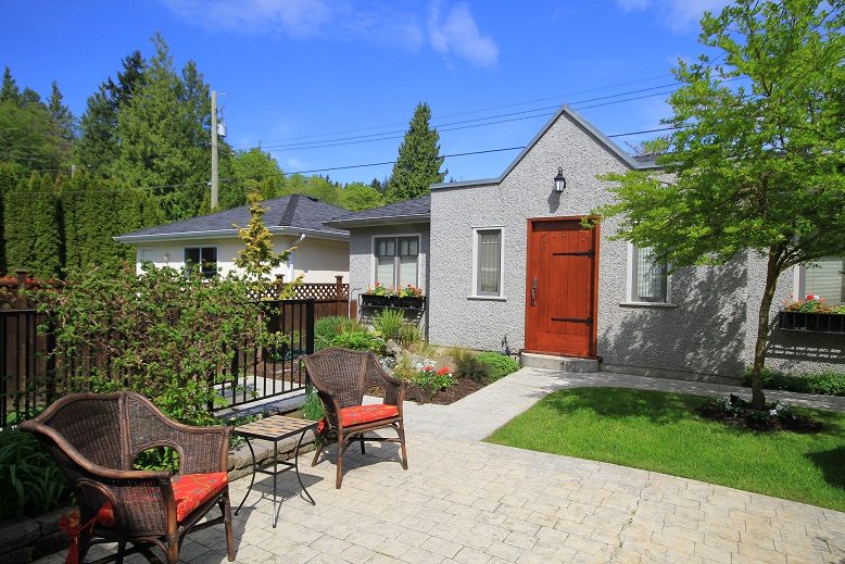 Furnished patio with wicker chairs, small table, and garden bed. - 4069 West 37th Ave, Vancouver West Side