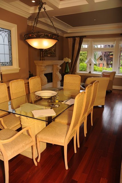 Elegant dining room with hardwood floors, large windows, and a glass-top table. - 4069 West 37th Ave, Vancouver West Side