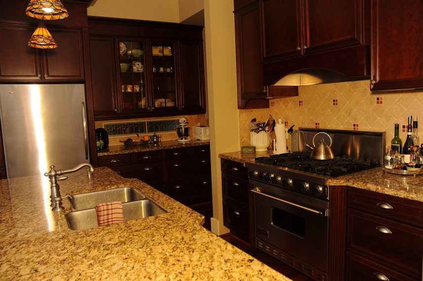 Bright kitchen with granite countertops, stainless steel appliances, and dark wood cabinetry. - 4069 West 37th Ave, Vancouver West Side