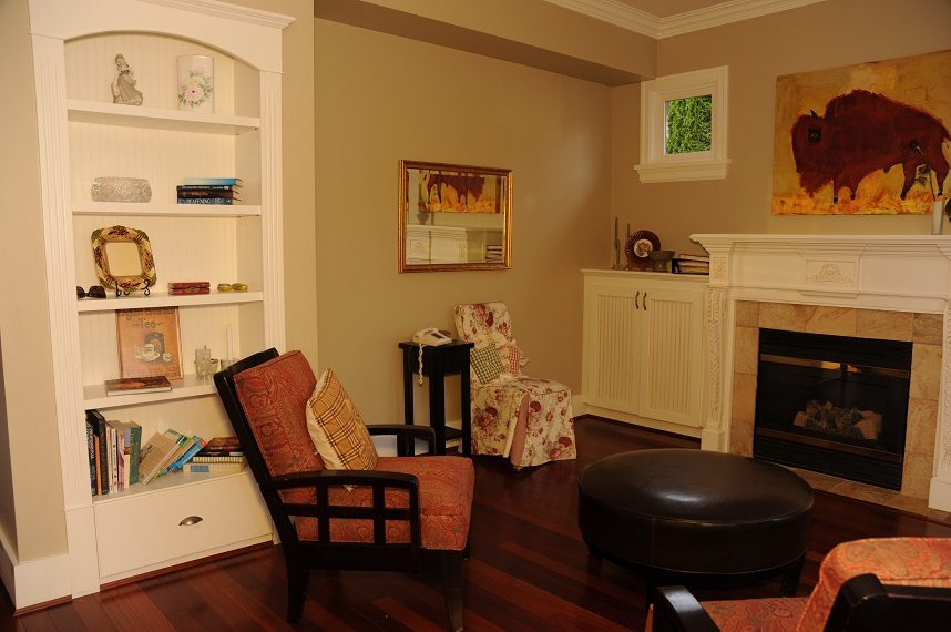 Furnished living room with hardwood floors, a fireplace, and a bookshelf. - 4069 West 37th Ave, Vancouver West Side