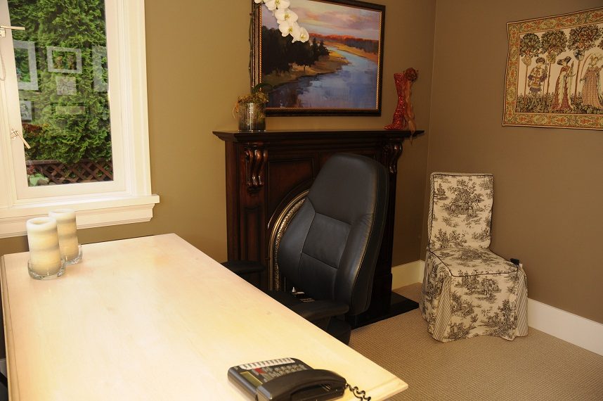Furnished office space with a leather chair, toile-patterned chair, and a fireplace mantel. - 4069 West 37th Ave, Vancouver West Side