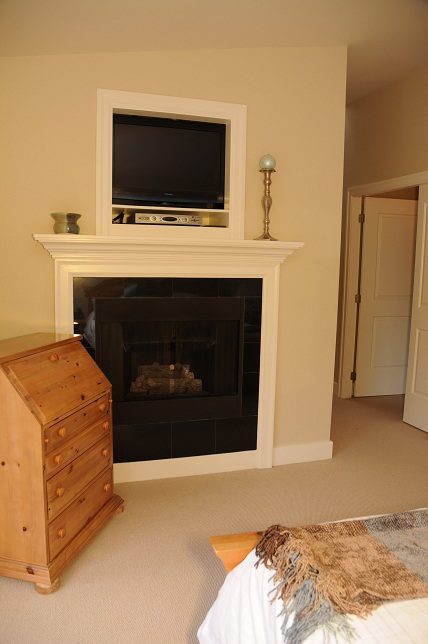 Furnished living room with a fireplace and mounted TV, neutral decor. - 4069 West 37th Ave, Vancouver West Side