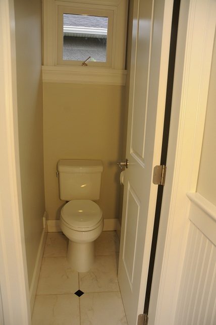 Small bathroom with a toilet and a window above it. - 4069 West 37th Ave, Vancouver West Side