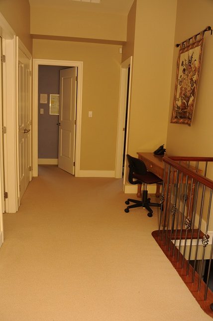 Furnished hallway with carpeted floors and a desk with a chair. - 4069 West 37th Ave, Vancouver West Side