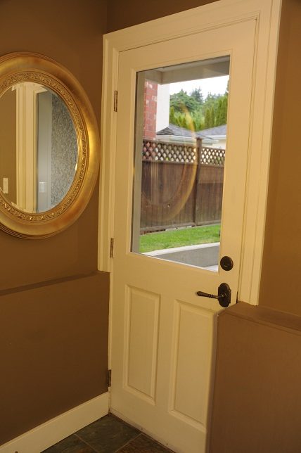 Foyer with a decorative mirror and a view of the backyard. - 4069 West 37th Ave, Vancouver West Side
