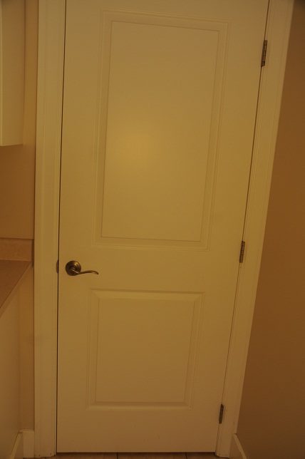 Furniture in progress, door with brass handle, beige walls. - 4069 West 37th Ave, Vancouver West Side