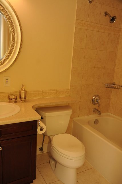 Bathroom with beige tiles, countertop, and dark vanity. - 4069 West 37th Ave, Vancouver West Side
