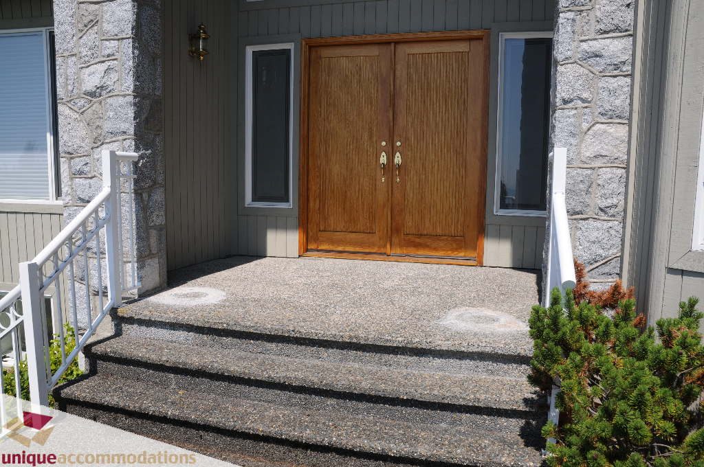 Bright entryway with wooden double doors and stone steps leading up to the front door. - 4139 Citadel Court, North Vancouver
