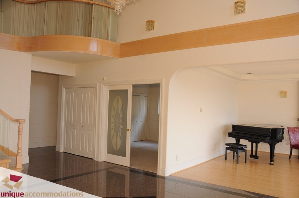 Spacious living room with hardwood floors and a grand piano. - 4139 Citadel Court, North Vancouver