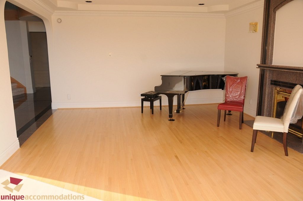 Living room with hardwood floors and a piano, spacious and inviting. - 4139 Citadel Court, North Vancouver