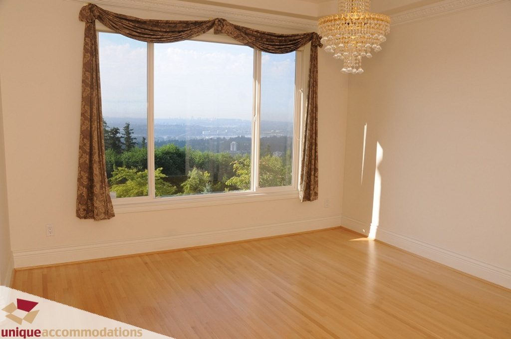 Bright living room with hardwood floors and a stunning city view. - 4139 Citadel Court, North Vancouver