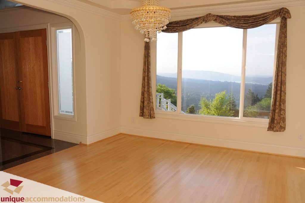 Bright living room with hardwood floors, bay window, and city view. - 4139 Citadel Court, North Vancouver