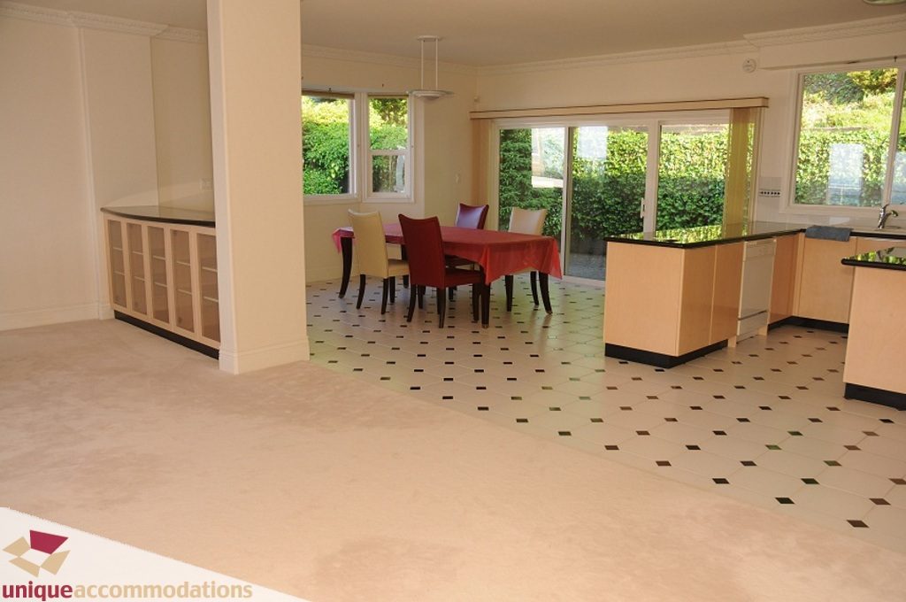 Open dining area with red tablecloth, light wood cabinets, and checkered floor tiles. - 4139 Citadel Court, North Vancouver