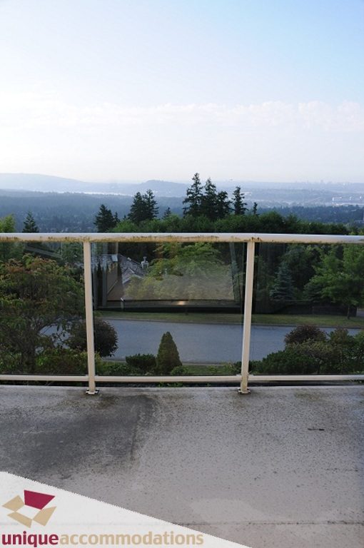 Balcony with city view and lush greenery. - 4139 Citadel Court, North Vancouver