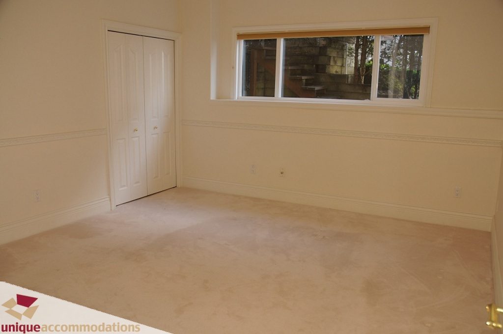 Bright bedroom with white walls, closet, and window view. - 4139 Citadel Court, North Vancouver