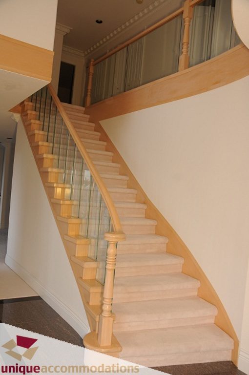 Staircase with wooden banister and carpeted steps leading to upper level. - 4139 Citadel Court, North Vancouver