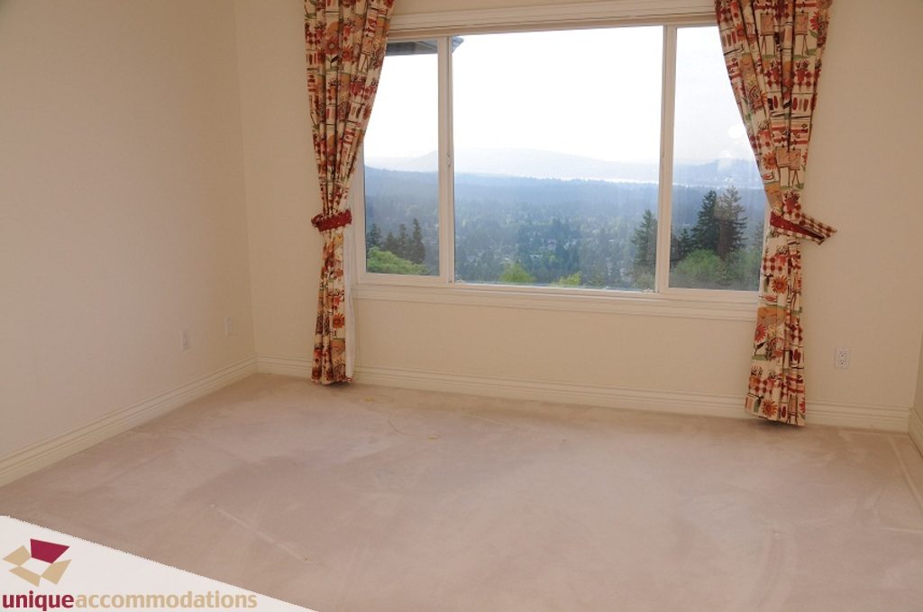 Bright living room with large windows and a scenic view of the mountains. - 4139 Citadel Court, North Vancouver