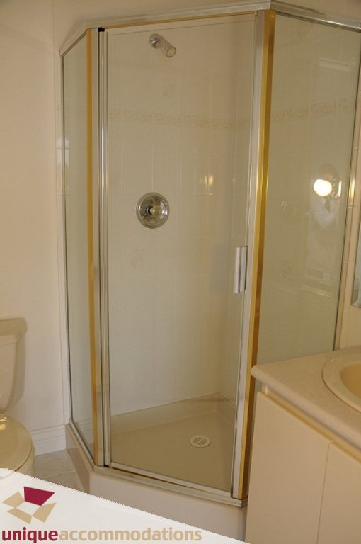 Bright bathroom with white countertop and corner shower. - 4139 Citadel Court, North Vancouver